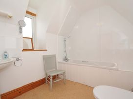A bathroom with a bath tub and sink at Seaworthy in Daymer Bay