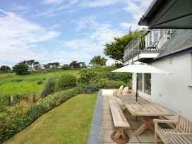 A garden with a table and chairs at Seaworthy in Daymer Bay