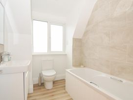 A bathroom with a toilet, sink and bathtub at Seaworthy in Daymer Bay