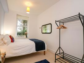 A bedroom with a bed and a clothes rack at 2 The Old School House