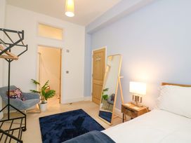 A bedroom with a bed and mirror at 2 The Old School House in 