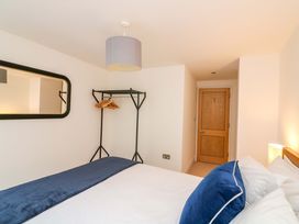 A bedroom with a bed and a clothes rack at 2 The Old School House