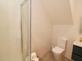 A bathroom with a shower, toilet, and sink at 2 The Old School House 