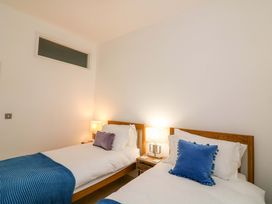 A bedroom with two single beds and bedside lamps at 2 The Old School House 