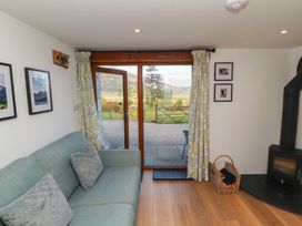 A living room with a sofa and fireplace at Wren's Nest in Thornthwaite near Braithwaite