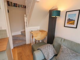 A living room with a sofa and a staircase at Wren's Nest in Thornthwaite near Braithwaite