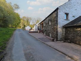 A roadside view of a stone house and garden at Wren's Nest Thornthwaite near Braithwaite