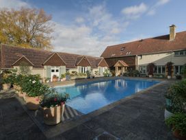 An outdoor area with a swimming pool and house at Cottage - 1 bedroom, Broadway