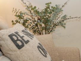 A living room with a pillow and plant at Cottage - 1 bedroom Broadway