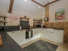 A kitchen with cabinets and shelves at Cottage - 1 bedroom in Broadway