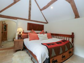 A bedroom with a bed and wooden furniture at Cottage - 1 bedroom Broadway