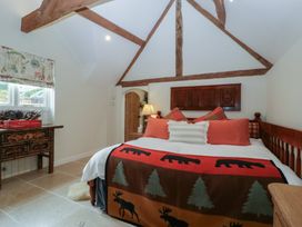 A bedroom with a bed and wooden furniture at Cottage - 1 bedroom in Broadway