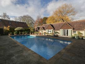 An outdoor swimming pool surrounded by paved area at Cottage - 1 bedroom Broadway