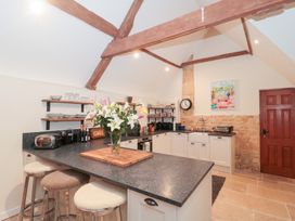 A kitchen with a countertop and bar stools at Garden Cottage in Saintbury near Broadway