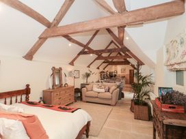 A living room with a sofa and dining area at Garden Cottage in Saintbury near Broadway
