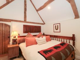A bedroom with a bed and wooden door at Garden Cottage in Saintbury near Broadway
