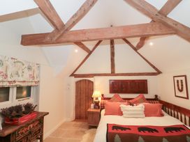 A bedroom with a bed and wooden beams at Garden Cottage in Saintbury near Broadway