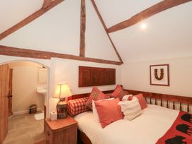 A bedroom with a bed and decorative pillows at Garden Cottage in Saintbury near Broadway