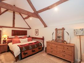 A bedroom with a bed and wooden furniture at Garden Cottage in Saintbury near Broadway