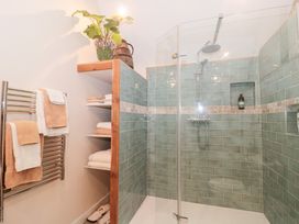 A bathroom with a shower and towels at Garden Cottage in Saintbury near Broadway