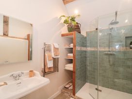 A bathroom with a shower, sink, and towels at Garden Cottage in Saintbury near Broadway