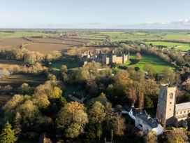 An aerial view of a castle and church surrounded by fields at 5 St. Michaels Close Framlingham