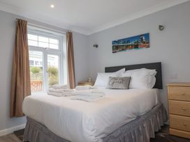 A bedroom with a bed and nightstand at Satinwood in White Cross near Newquay