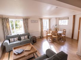 A living room with a sofa and dining table at Stable Cottage Lechlade-On-Thames