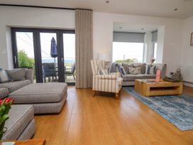 A living room with sofas armchair wooden coffee table and a rug at Buzzards View in Dyserth