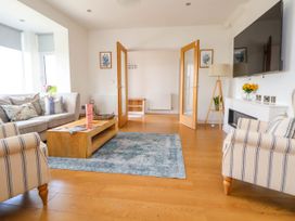 A living room with sofas coffee table rug and wall mounted television at Buzzards View in Dyserth