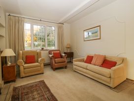 A living room with two armchairs a sofa and a rug on the floor at The Coach House in Abergavenny