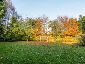 A grassy garden with autumn trees and a soccer goal at The Coach House in Abergavenny