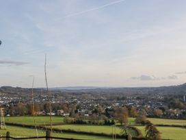 An expansive rural landscape with fields trees and a town in the distance at The Coach House in Abergavenny