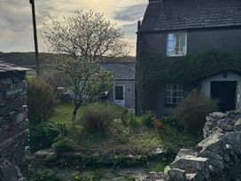A cottage with a garden and a tree surrounded by stone walls at The Old Cottage Oxen Park near Ulverston