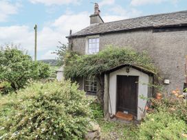 A cottage entrance surrounded by plants and a path at Old Cottage in Oxen Park near Ulverston