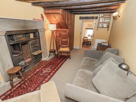 A living room with a fireplace and seating area at Old Cottage in Oxen Park near Ulverston