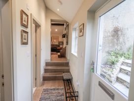 A hallway with staircase and framed pictures at The Old Cottage in Oxen Park near Ulverston