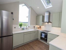 A kitchen with a refrigerator, sink, and oven at The Old Cottage in Oxen Park near Ulverston