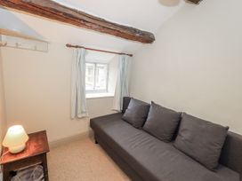 A sitting room with a sofa and lamp at Old Cottage in Oxen Park near Ulverston