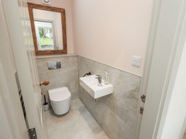 A bathroom featuring a toilet, sink, and window at Old Cottage in Oxen Park near Ulverston