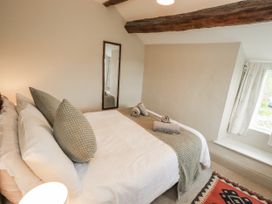 A bedroom with a bed and towels at Old Cottage in Oxen Park near Ulverston