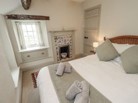 A bedroom with a bed and towels on the bed at Old Cottage in Oxen Park near Ulverston