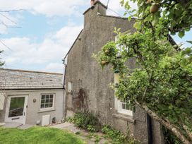 An outdoor area with a house and tree at Old Cottage Oxen Park near Ulverston