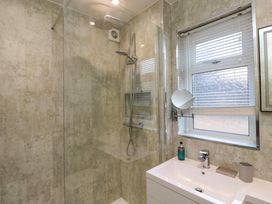 A bathroom with a walk-in shower and a sink under a window at Number Ten in Amble
