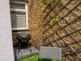 A patio area with a grill and a chair at Number Ten in Amble