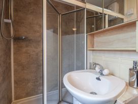 A bathroom with a corner shower and a sink with a faucet at Willebby in South Chard