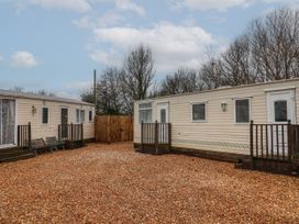 Two beige mobile homes with small wooden porches and a gravel yard between them at Willebby in South Chard