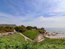 A coastal path leading to a historic fortification by the sea with grassy hills and a sandy beach at Willebby in South Chard