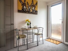 A small dining area with a table and two chairs near a door with patterned glass at Bobbys Lodge in South Chard