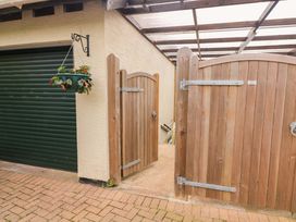 An outdoor area with wooden gates and a garage door at Garden View in Hillhead near Brixham